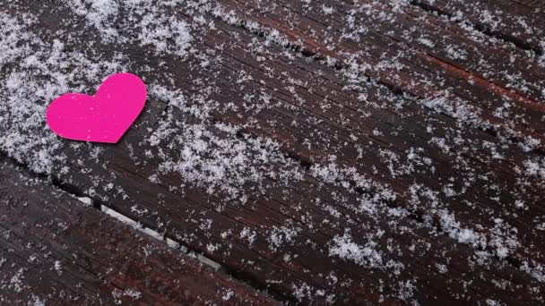Valentinstag Seite Schneeflocken Fallen Auf Einen Dunklen Holztisch Mit Rosa — Stockvideo