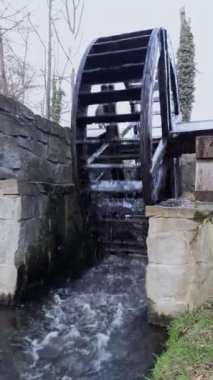 Work of water mill. Vertical video of water wheel that demonstrates principle of hydropower. Concept of clean and alternative energy sources, conservation and nature protection. Pollution control.