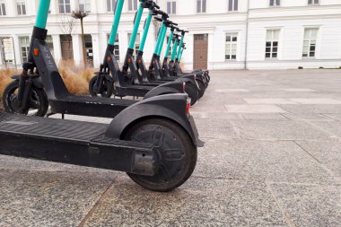 Renting electric scooter is economical transport for city for every day. Selective focus.  Electric transport on blurred background of urban landscape. Concept reduction of exhaust gases.