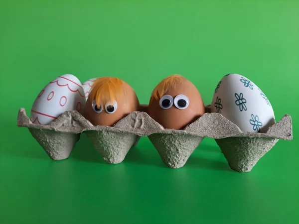 Gözleri ve kahkülleri olan komik yumurtalar. Yaratıcı Paskalya Yumurtası Dekorasyonu Fikirleri. Farklı dekorlu Paskalya yumurtası tepsisi. Çocuklar ve Yetişkinler için Paskalya El Sanatları. Seçici odaklanma. Tatil için hazırlık.