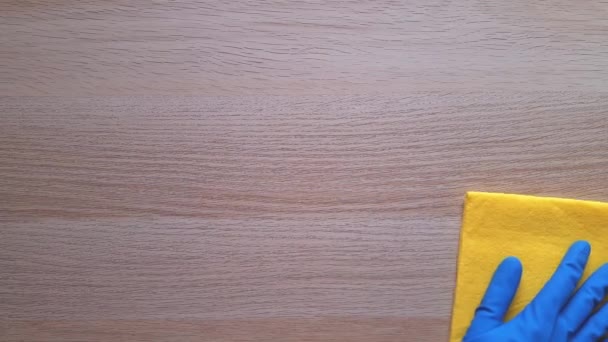 掃除屋だ 洗浄と洗浄時間の概念 黄色のラグを持つ青保護ゴム手袋で手は木製のテーブルを拭く ほこりや汚れの除去 毎日の家事 — ストック動画