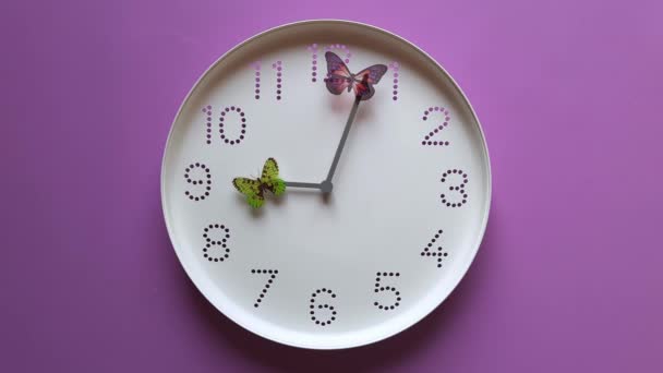 蝶の腕時計 時間管理の概念は 生活の速い流れ 時間の不足 紫色の背景に手をクローズアップで蝶と白い機械式時計 時間は９時から速く走っている — ストック動画