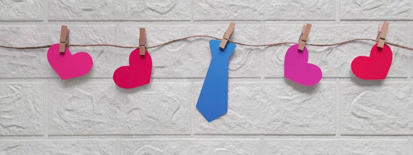 Banner with tie and hearts on rope. Father\'s Day gifts. Funny garland for Father\'s Day, birthday, bachelor party, anniversary. Preparation for holiday. Header for website, blog, article, advertisement.