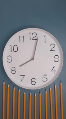 Saat ileri gidiyor. Mavi masa arkasında beyaz saat yüzlü, kurşun kalemli bir saat. Hiperlapse. Öğrenim anlayışı, son teslim tarihi, takvim.
