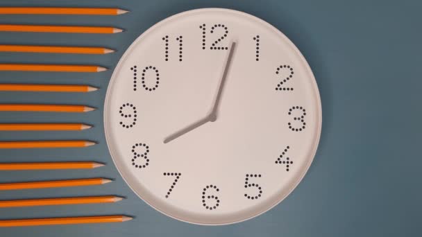 時計は速く動いている 鉛筆で青のテーブルの背景に白い時計の顔で見てください ハイパーラプス 締め切り スケジュールの概念 — ストック動画