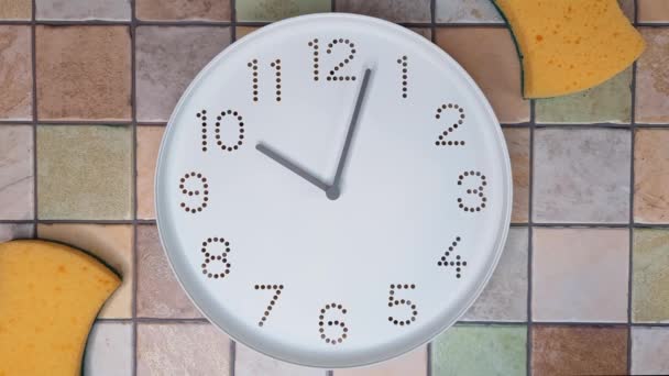 10点 清洗时间 上午10点后钟表指针的时钟方向移动 钟表和厨房海绵在瓷砖墙的背景上 一日一餐 概念中的深层清洁厨房 — 图库视频影像