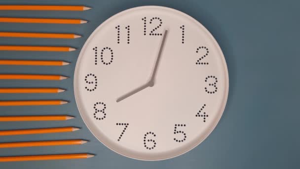 时钟运行得很快 用铅笔在蓝色的桌子背景上用白色的钟面看着 学习概念 截止日期 时间表 — 图库视频影像
