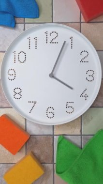 4 oclock. Cleaning time. Timelapse. Clockwise movement of clock hands after four oclock. Clock, kitchen cleaning sponge, microfiber cloth on tiled wall background. Tips for quick house cleaning