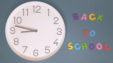 Okula dönelim. 9 kilit. Duvarın arka planında beyaz saat yazılı. Dokuza çeyrek kala ile dokuzu çeyrek geçiyor. Öğrenim ve yeni öğrenim yılı konsepti. Hiperlapse.