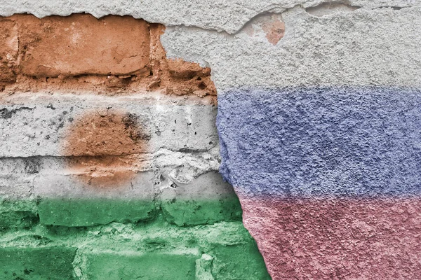 Nijer ve Rusya. Rus ve Nijerya bayrağı. Tuğla duvarın arkasındaki ülkelerin bayrakları. Sokak sanatı. Diplomatik ilişkiler. Afrika 'daki ve dünyadaki küresel süreçler.