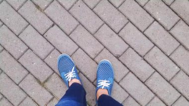Mavi mokasenli ayaklar kaldırımda duruyor. Yukarıdan bak. İnsan suyun üzerinde yürüyor, bir ayağından diğerine kayıyor. Bekliyorum, bacaklarım yoruldu, ısınıyorum. Kişisel bakış açısından selfie.