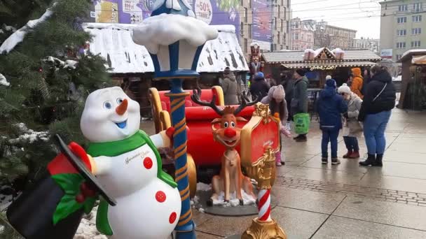 伝統的なフェアでは 大晦日の雪だるまと鹿の背後から歩きます クリスマスマーケット 2023 Market Square Katowice ポーランド ヨーロッパ クリスマスマーケット — ストック動画