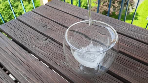 屋外のテーブルにガラスに注ぐ水 天然ガラスタンブラーの新鮮な水 水分補給ドリンク — ストック動画
