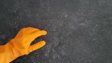 Karanlık arka planda iyi niyet göstergesi. Turuncu kauçuk temizleme eldiveni onay işareti gösteriyor. Temizlikçi avuçla iyi bir hareket gösteriyor. Metin, mesaj, tasarım için boş alan.