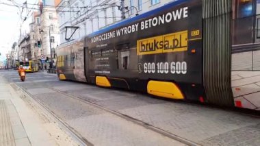 Şehir Modern elektrikli toplu taşıma. Otobüs ve tramvay, tarihi mimari ve yayaların arka planına karşı bir Avrupa şehrinin merkezinde seyahat ediyor. 27-03-2024 Katowice, Polonya, Avrupa.