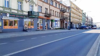 Şehir trafiği. Otobüsler ve arabalar tarihi binaları olan bir Avrupa şehrinin merkezinde yol boyunca ilerlerler. 23-04-2023 Sosnowiec, Polonya, Avrupa