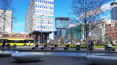 Şehir merkezindeki dinlenme alanı. Rahat banklar, modern ve tarihi binaların arka planına karşı iş bölgesinde su kanalının yanında duruyor. 27-03-2024 Katowice, Polonya, Avrupa.