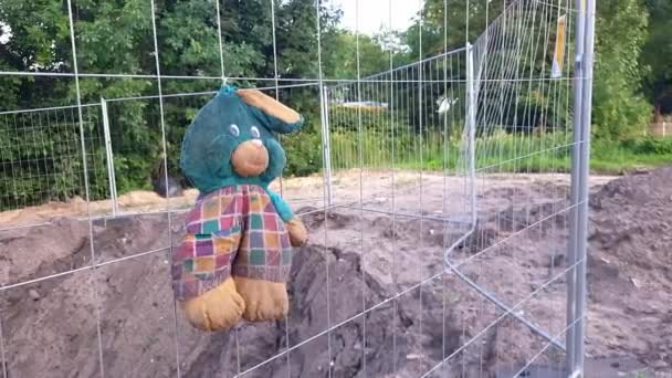 Parenting Challenges Symbol Old Abandoned Plush Bunny Hangs Construction Fence — Stock Video