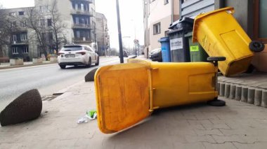 Çöp tenekelerini devirdim. Şehrin ana caddesinde çöp. Avrupa şehirlerinde atık temizleme ve imha sorunu. 10-03-2024 Sosnowiec, Polonya, Avrupa. 