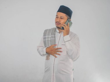 Moslem Asian man calling his family during Ramadan celebration clipart