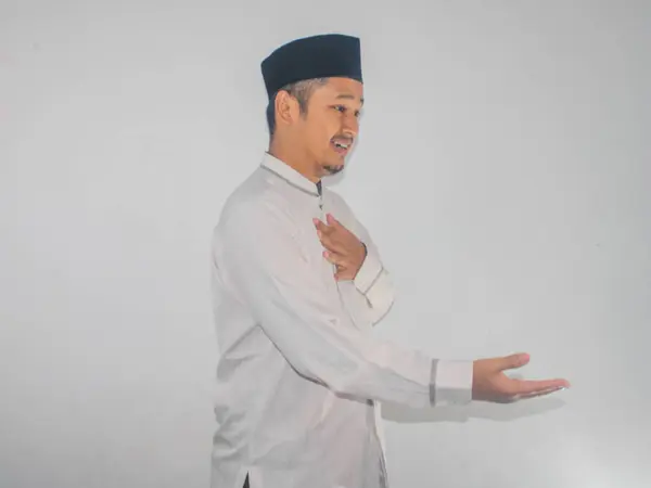 Müslüman Asyalı adam el sıkışırken dostça gülümsüyor.