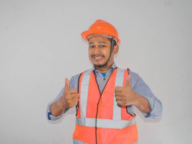 A man wearing construction hardhat smiling and give two thumbs up clipart