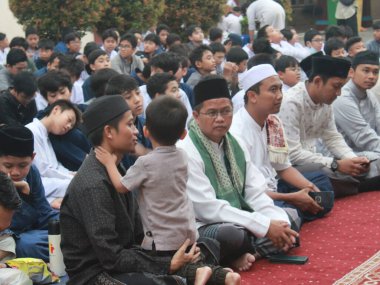 Ortaokul öğrencileri, 29 Mart 2024 'te Endonezya' nın okul ve cami bölgesinde birlikte kahvaltı etmeden önce bir konferans dinliyorlar.