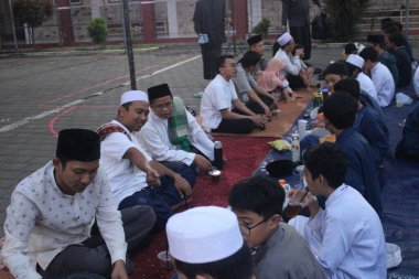 Ortaokul öğrencileri, 29 Mart 2024 'te Endonezya' nın okul ve cami bölgesinde birlikte kahvaltı etmeden önce bir konferans dinliyorlar.