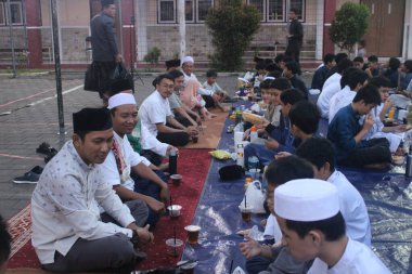 Ortaokul öğrencileri, 29 Mart 2024 'te Endonezya' nın okul ve cami bölgesinde birlikte kahvaltı etmeden önce bir konferans dinliyorlar.