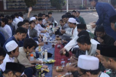 Ortaokul öğrencileri, 29 Mart 2024 'te Endonezya' nın okul ve cami bölgesinde birlikte kahvaltı etmeden önce bir konferans dinliyorlar.