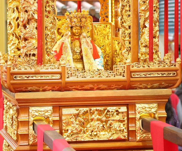 Tahtırevandaki altın bir tanrı heykelinin yakın çekimi.