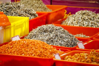  Yeşil plastik bir kap gri küçük kurutulmuş balıkla doludur.