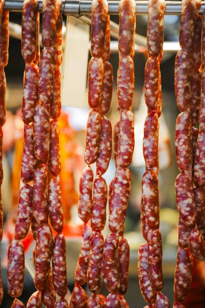 Bir sıra Tayvan sosisi tezgahta asılı duruyor.