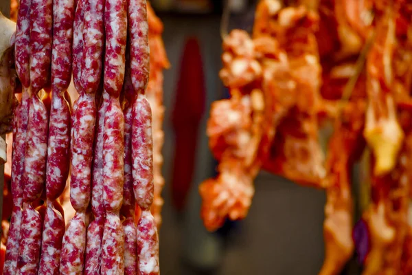 Bir sıra Tayvan sosisi tezgahta asılı duruyor.