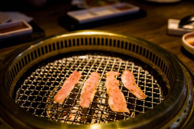 Yeni hazırlanmış et dilimlerinin pişirildiği bir ızgara.