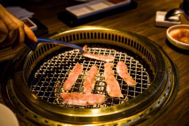 Yeni hazırlanmış et dilimlerinin pişirildiği bir ızgara.