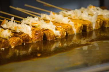  Tofu mangal kömürü üzerinde kızartılıyor.