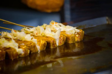  Tofu mangal kömürü üzerinde kızartılıyor.