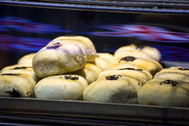 Cam bir kutunun arkasında taze pişmiş Çin susamlı kek koleksiyonu.