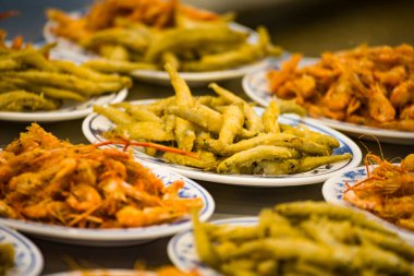 Altın ve çıtır çıtır kızarmış acı çiçek balığı tabakları, baştan çıkarıcı bir aroma yayarak düzenli bir şekilde yerleştirilmiştir.