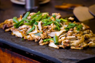Yaban domuzu ve soğan çabucak teppanyaki ızgarasında kızartılır.