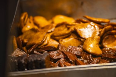 çeşitli ağır ateşte pişirilmiş yemekler metal bir tepside güzelce sergilenir.