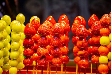 Bir kaç renkli tanghulu ahşap bir bölmede düzgünce düzenlenmiştir.