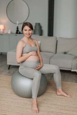 Annemin elleri hamile karnında. Hamile genç bir kadın hamile karnını okşuyor. Bekleyen anne bakımı. Annelik konsepti. Hamilelik. Mutlu bir aile. Yavaş çekim 4K. Yüksek kalite 4k görüntü