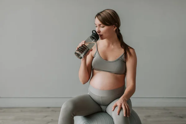 Lugn Gravid Kvinna Sitter Fitness Boll Efter Träning Och Dricksvatten — Stockfoto