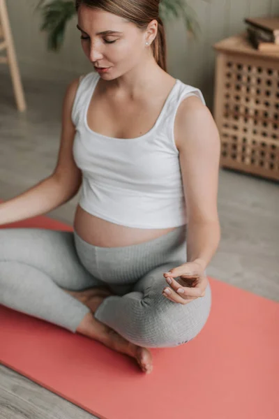 Top view of happy pregnant woman doing yoga exercises and stretching on mat in living room at home in the morning. Happy healthy pregnant concept 4k. High quality 4k footage