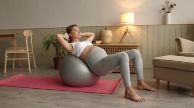 Yandan çekilen çekici hamile kadın. Gözleri kapalı. Spor salonunda egzersiz yapıyor. Yüksek kalite 4k görüntü