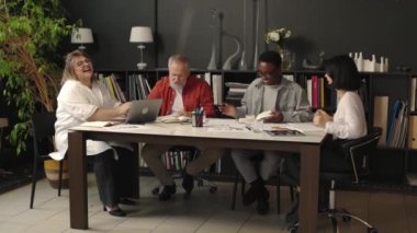 Çeşitli ofis ekipleri toplantıda. Mutlu genç meslektaşlar iş başarılarını ve planlarını tartışıyor. 4 bin. Yüksek kalite 4k görüntü