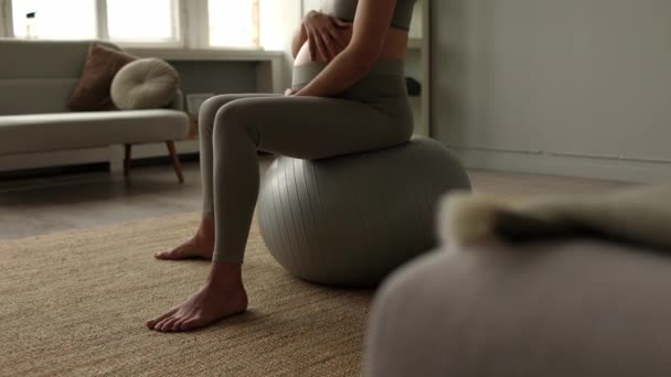 スポーツウェアの妊婦は自宅でフィットボールの練習を行う瞑想します 出産前の呼吸体操 生まれていない赤ん坊を持つ大きな腹 健康的なイメージの概念 妊娠中の女性のフィットネス — ストック動画