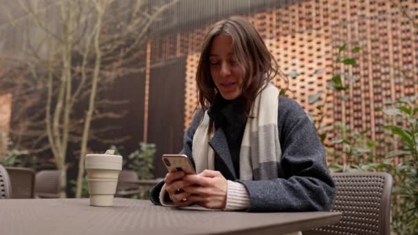 Gülümseyen Mutlu Bir Kadın Kampüste Şehir Merkezinde Paltosuyla Oturmuş Etrafa — Stok video